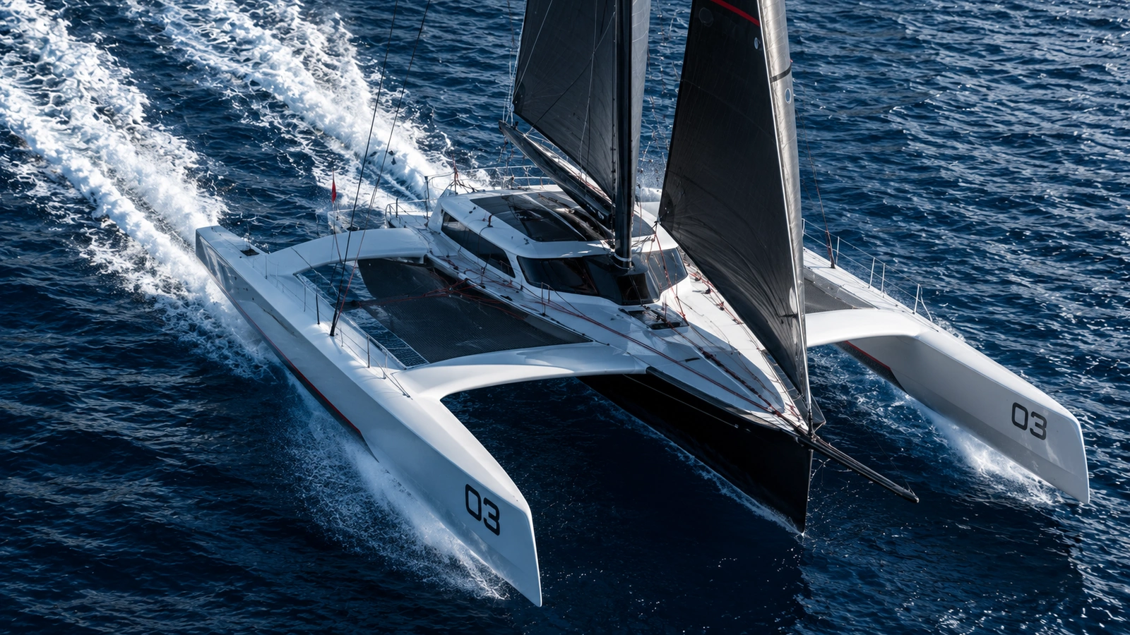 Fast trimaran cutting through deep blue water